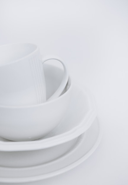 three white plates and a cup on a white background