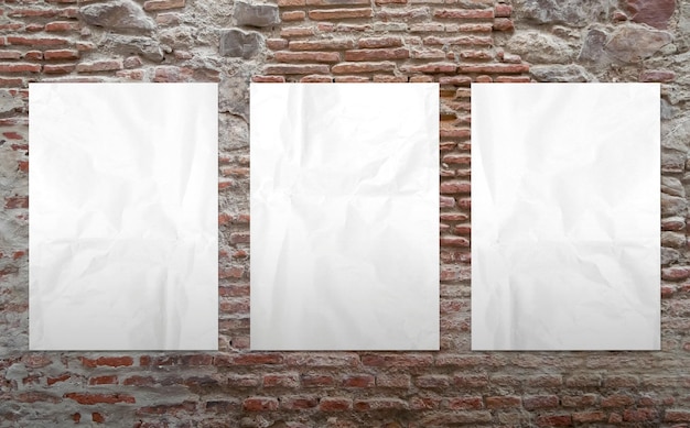 Foto gratuita tre manifesti bianchi in un muro di mattoni