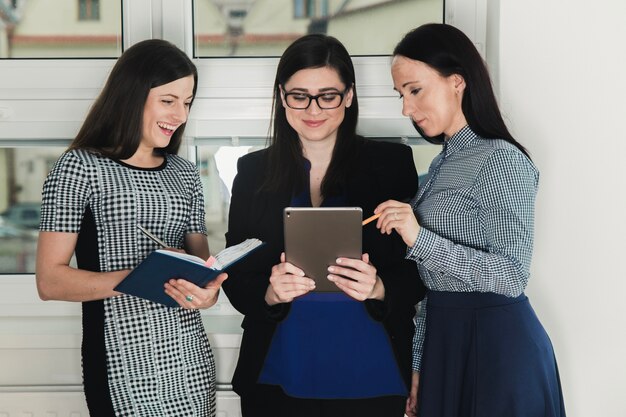 Three women with tablet and documents