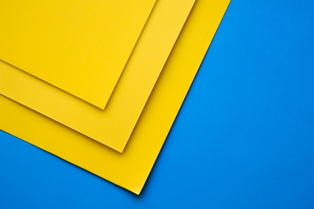 Three yellow craftpapers on blue backdrop