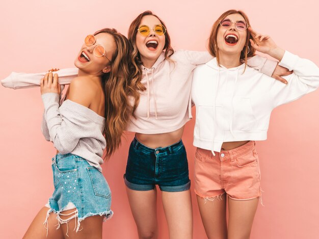 Three young beautiful smiling girls in trendy summer clothes. Sexy carefree women posing. Positive models having fun