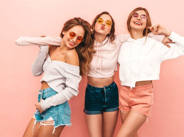 Three young beautiful smiling girls in trendy summer clothes. Sexy carefree women posing. Positive models having fun