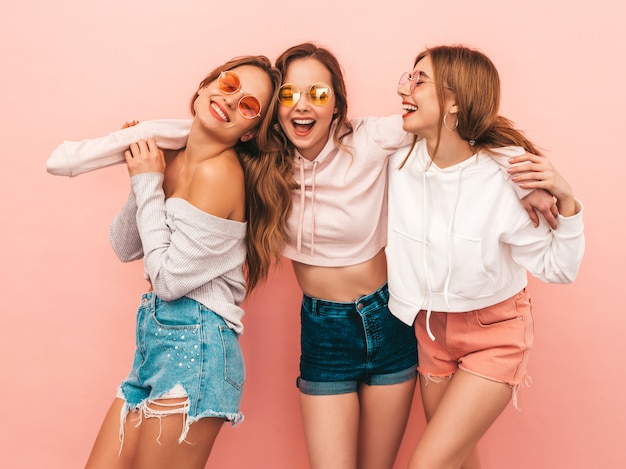 Three young beautiful smiling girls in trendy summer clothes. Sexy carefree women posing. Positive models having fun