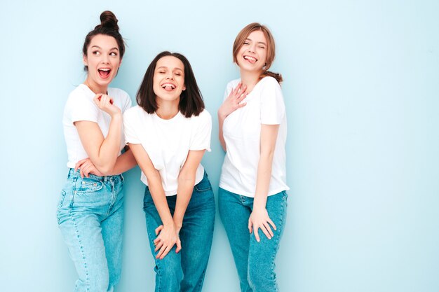 トレンディな同じ夏の白いTシャツとジーンズの服を着た3人の若い美しい笑顔の流行に敏感な女性