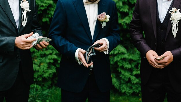 路上で結婚式のスーツでポーズをとってハンサムな男 無料の写真