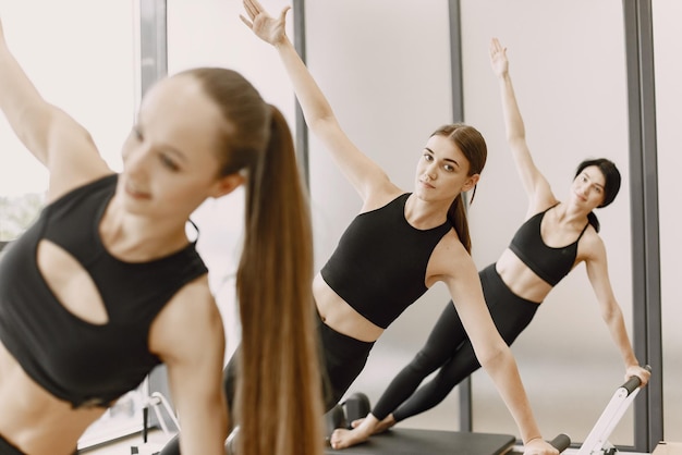 Three young fit women training in gym