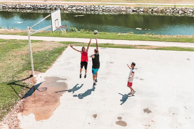 Three young male player playing basketball