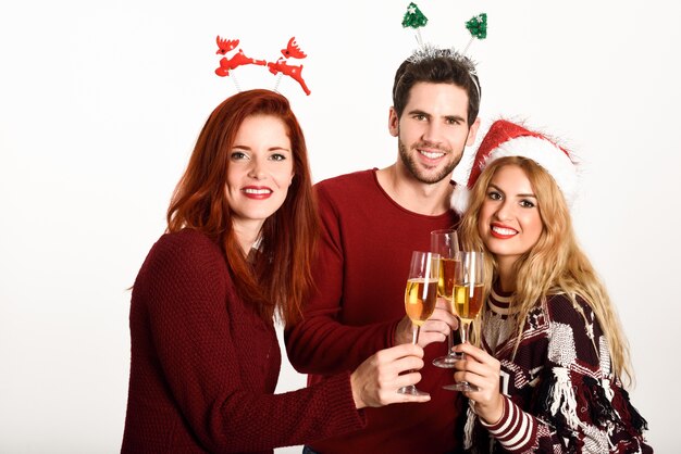 Three young people toasting with champagne on white background
