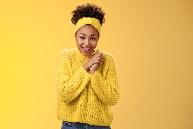 Thrilled cute charming african-american smiling girl cross fingers good luck press hands together grinning look hopefully camera praying good luck dream come true believe receive positive news