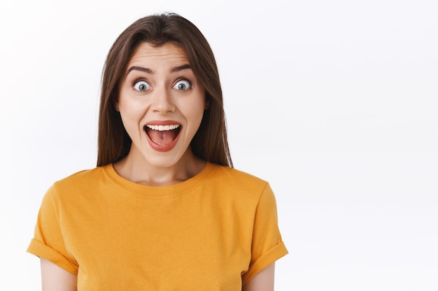 Thrilled, happy and joyful good-looking woman yelling from happiness and excitement, receive stunning awesome news, smiling surprised and glad, standing white background cheerful