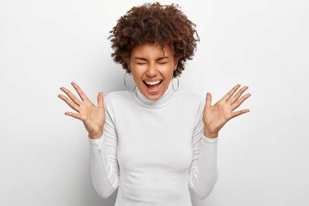 Thrilled joyful woman feels overemotive, laughs out from happiness