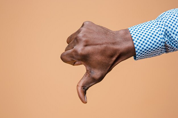 Большой палец вниз знак рукой на коричневом