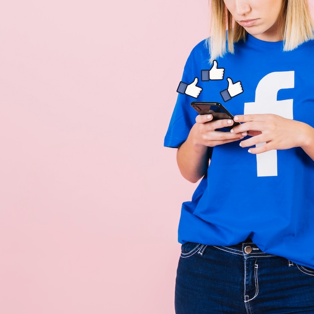 Free photo thumbs up sign over woman using smartphone