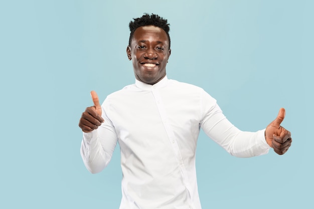 Thumbs up. Young african-american man isolated on blue studio