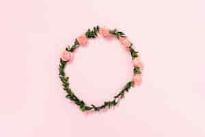 Foto gratuita tiara di rose e foglie artificiali su sfondo rosa
