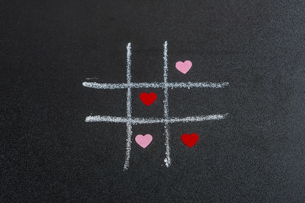 Tic tac toe game with little ornament hearts 