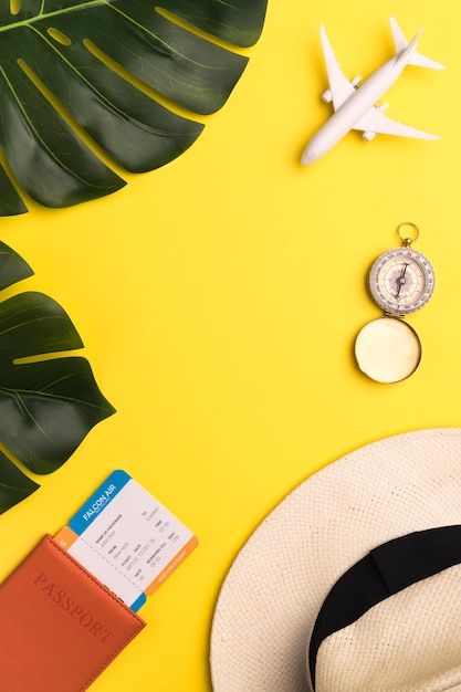 Tickets, compass and hat on yellow background