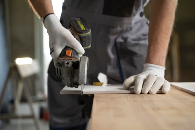 Free photo tiler working on renovation of apartment