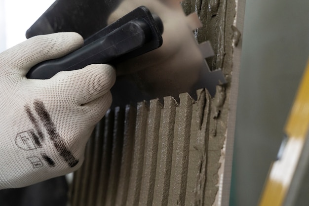 Free photo tiler working on renovation of apartment