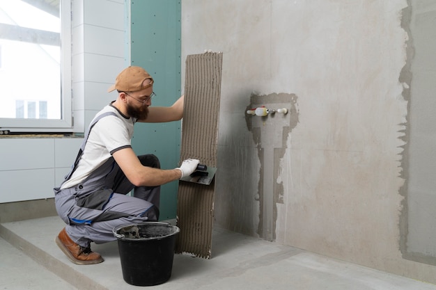 Free photo tiler working on renovation of apartment