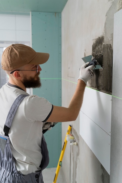 Free photo tiler working on renovation of apartment