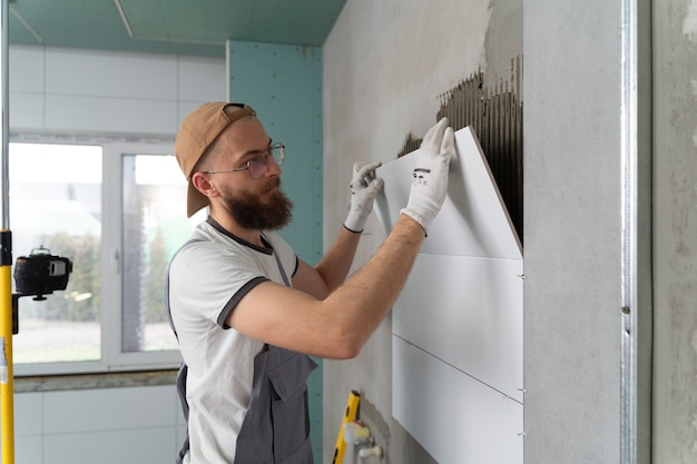 Free photo tiler working on renovation of apartment