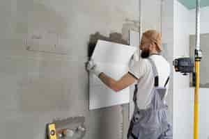 Free photo tiler working on renovation of apartment