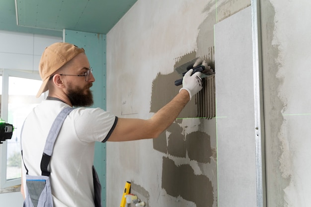 Free photo tiler working on renovation of apartment