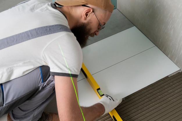 Free photo tiler working on renovation of apartment