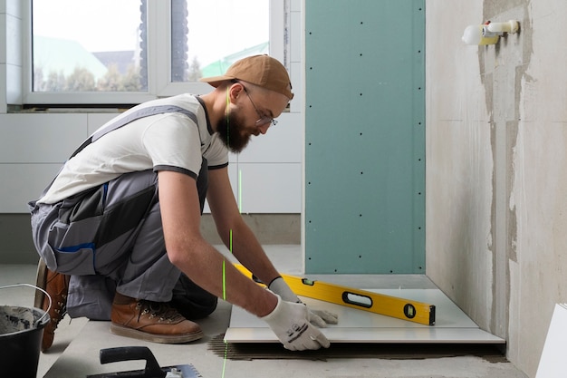 Free photo tiler working on renovation of apartment