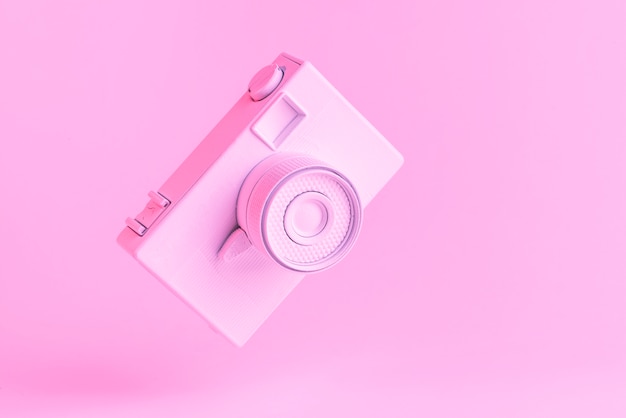 Tilt vintage camera against pink background