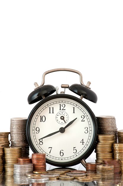 Концепция TIME IS MONEY: будильник и много монет евро