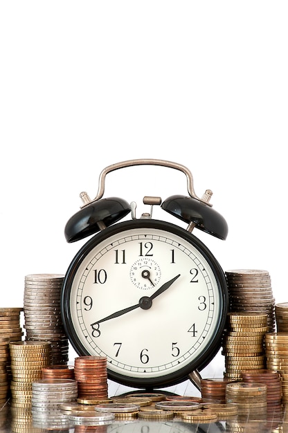 TIME IS MONEY concept: alarm clock and lots of euro coins