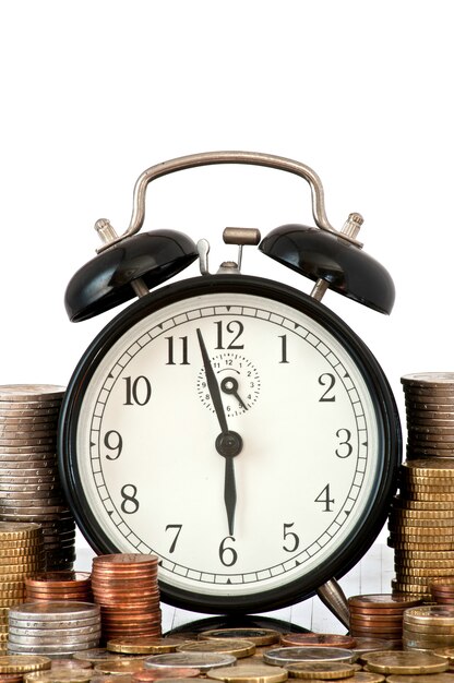 時間はマネーコンセプトです：目覚まし時計とたくさんのユーロコイン