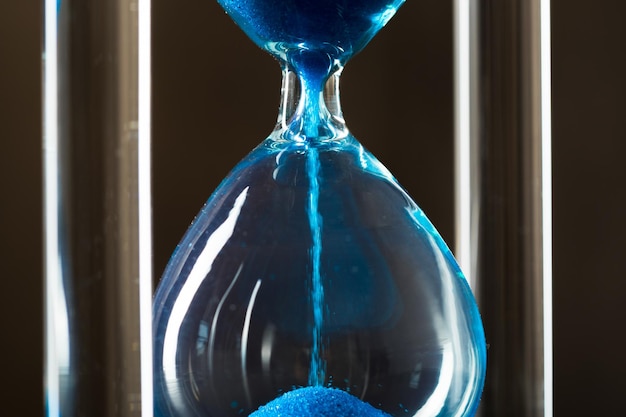 Free photo time is passing. blue hourglass close up