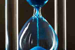 Free photo time is passing. blue hourglass close up