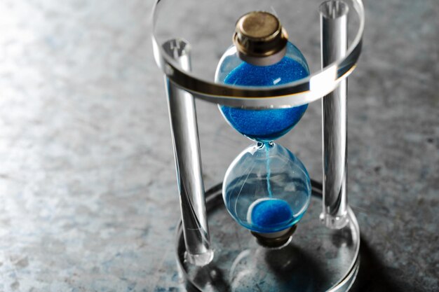 Time is passing. Blue hourglass close up