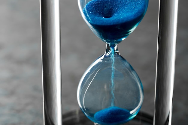 Time is passing blue hourglass close up