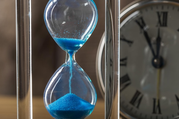 Time is passing. Blue hourglass close up