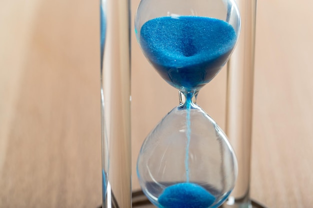 Time is passing. Blue hourglass close up