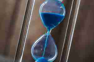 Free photo time is passing. blue hourglass close up