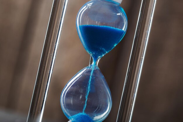 Time is passing. Blue hourglass close up