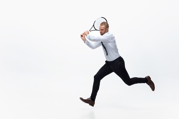 Time for movement. Man in office clothes plays tennis isolated on white.