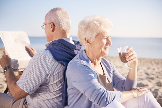 Free photo time to relax on the beach. senior couple in the beach, retirement and summer vacation concept