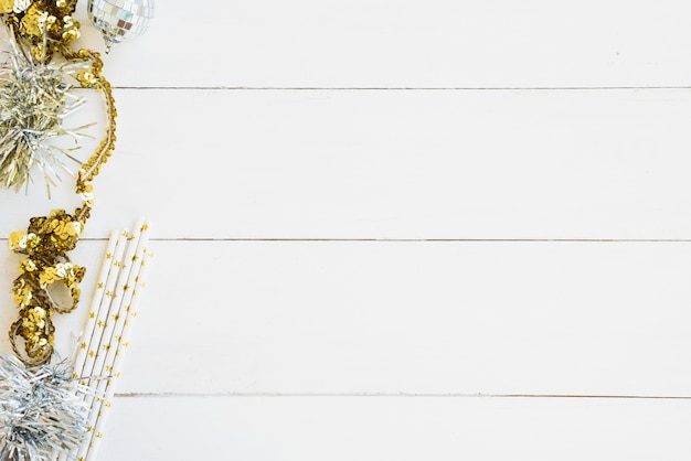 Tinsel with small bauble on wooden table