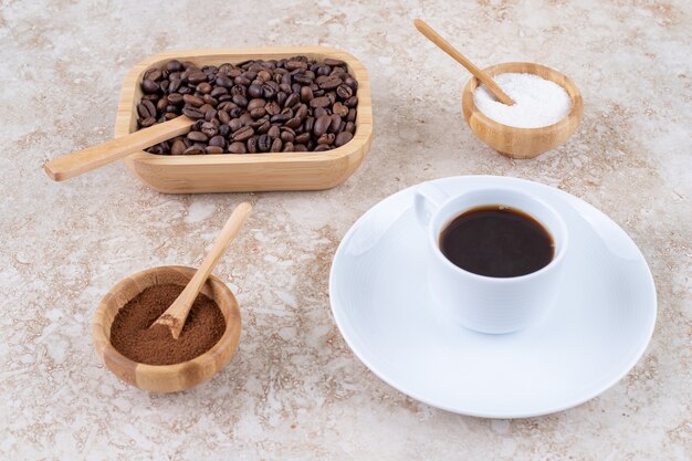 さまざまな形のコーヒーの横にある小さな砂糖のボウル
