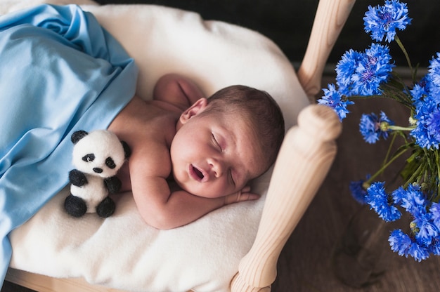 Крошечный ребенок под голубым одеялом