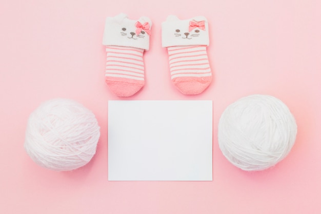 Free photo tiny socks with wool on pink