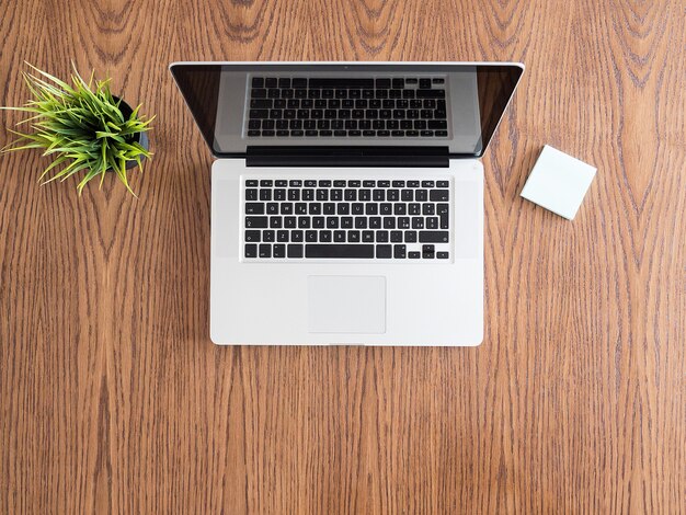 Tip view of businessman desk with a laptop and a pot of grass. Flatlay  image