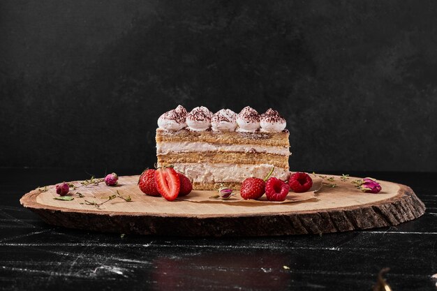 Tiramisu slice on a wooden platter .